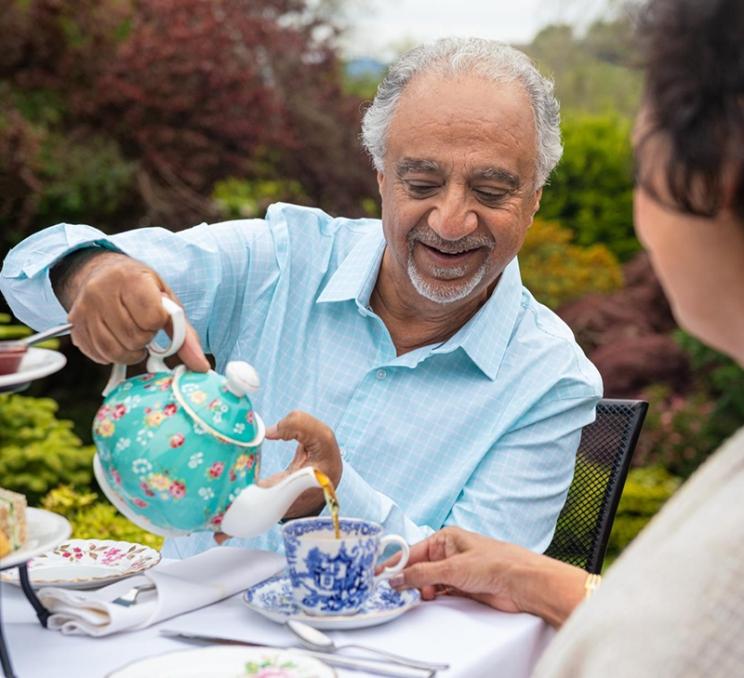 A gentleman pours his wife a cup of tea at afternoon tea in Victoria, BC